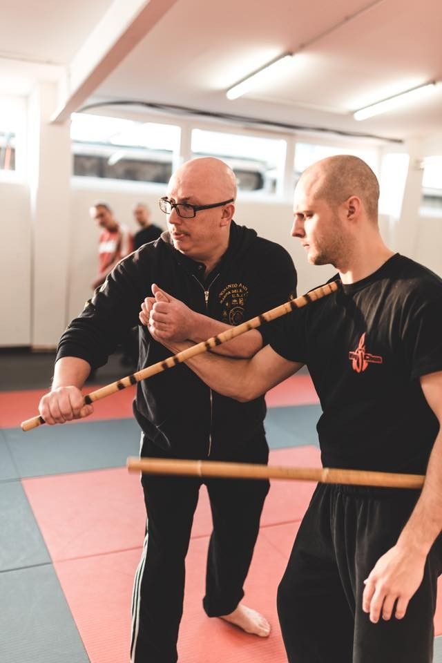 Zwei Kampftrainer und ein Schüler beim Üben auf der Matte