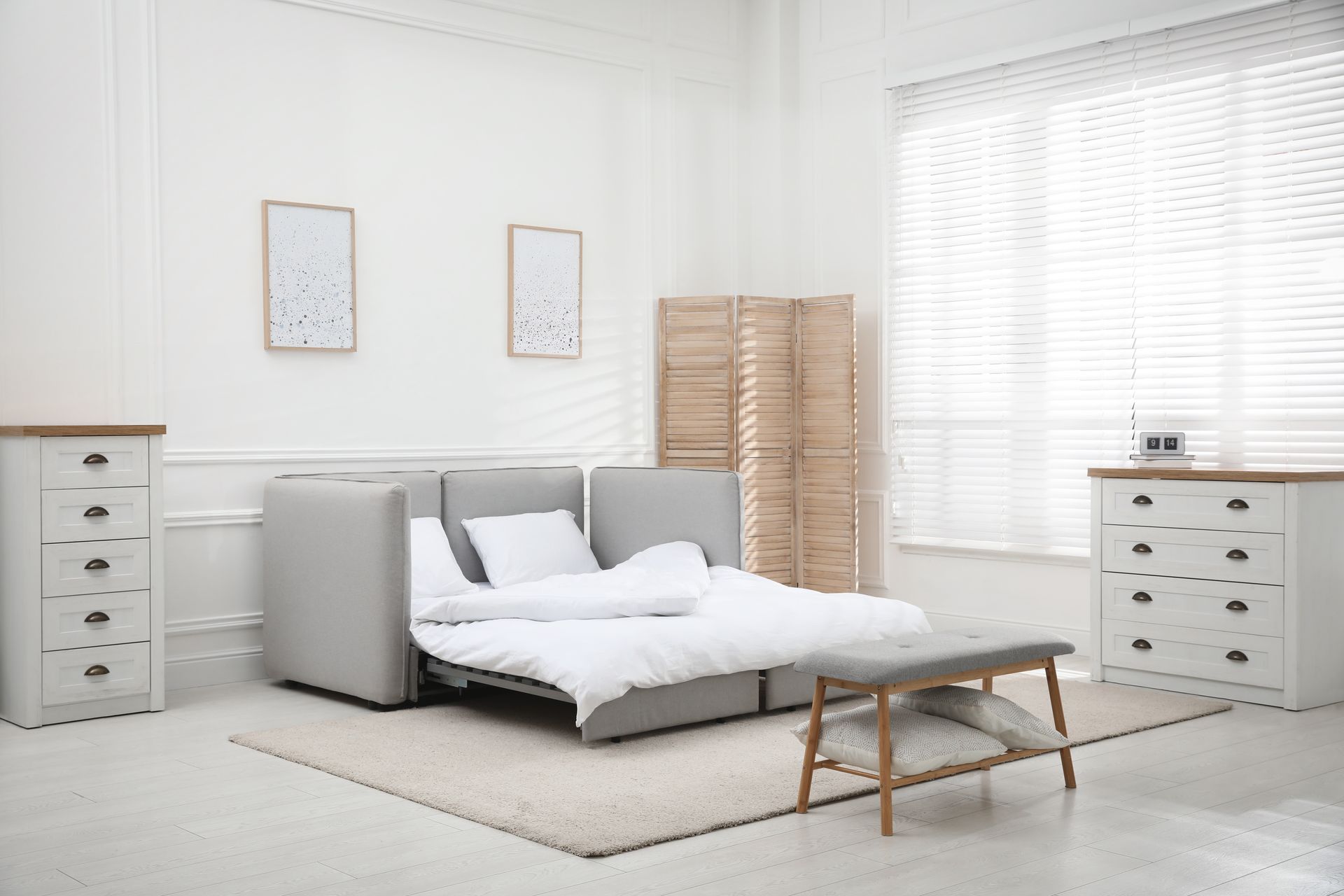 Un canapé convertible dans un salon gris clair