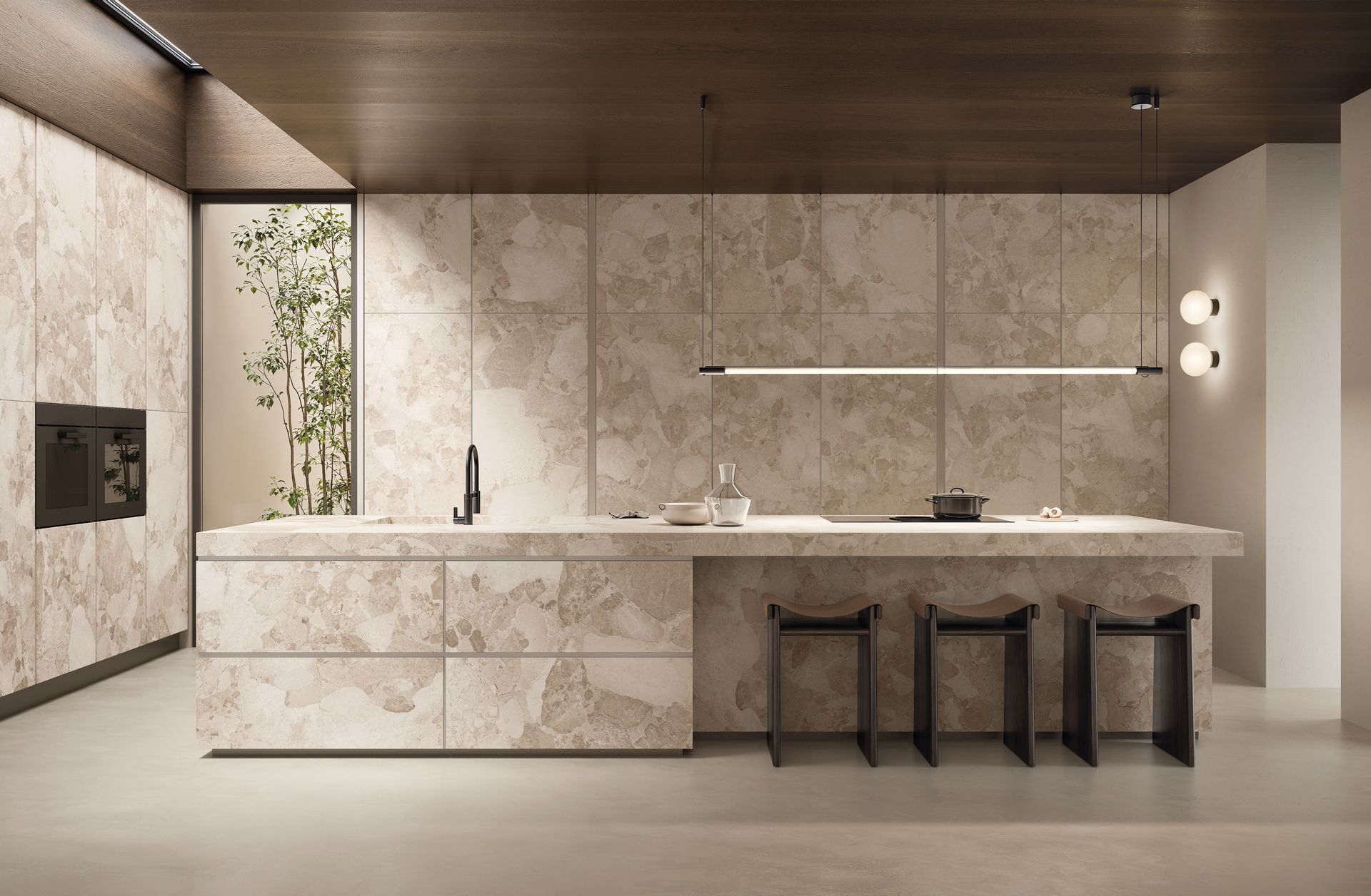 Salle de bains moderne et minimaliste avec murs en pierre, long meuble-lavabo suspendu et trois tabourets sous des suspensions lumineuses.