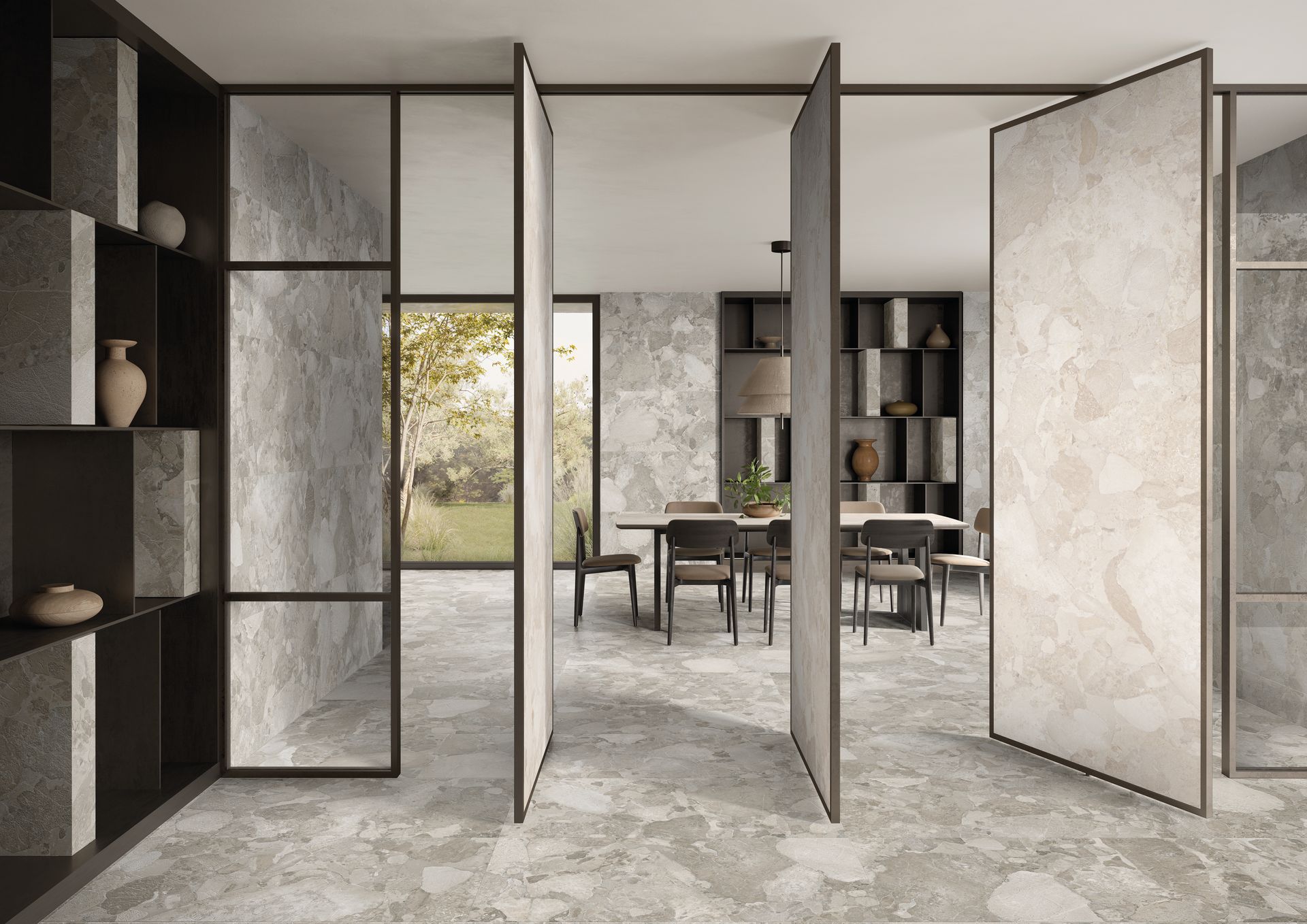 Intérieur moderne et ouvert avec de hautes portes pliantes, un sol en pierre, des étagères et un coin repas attenant.