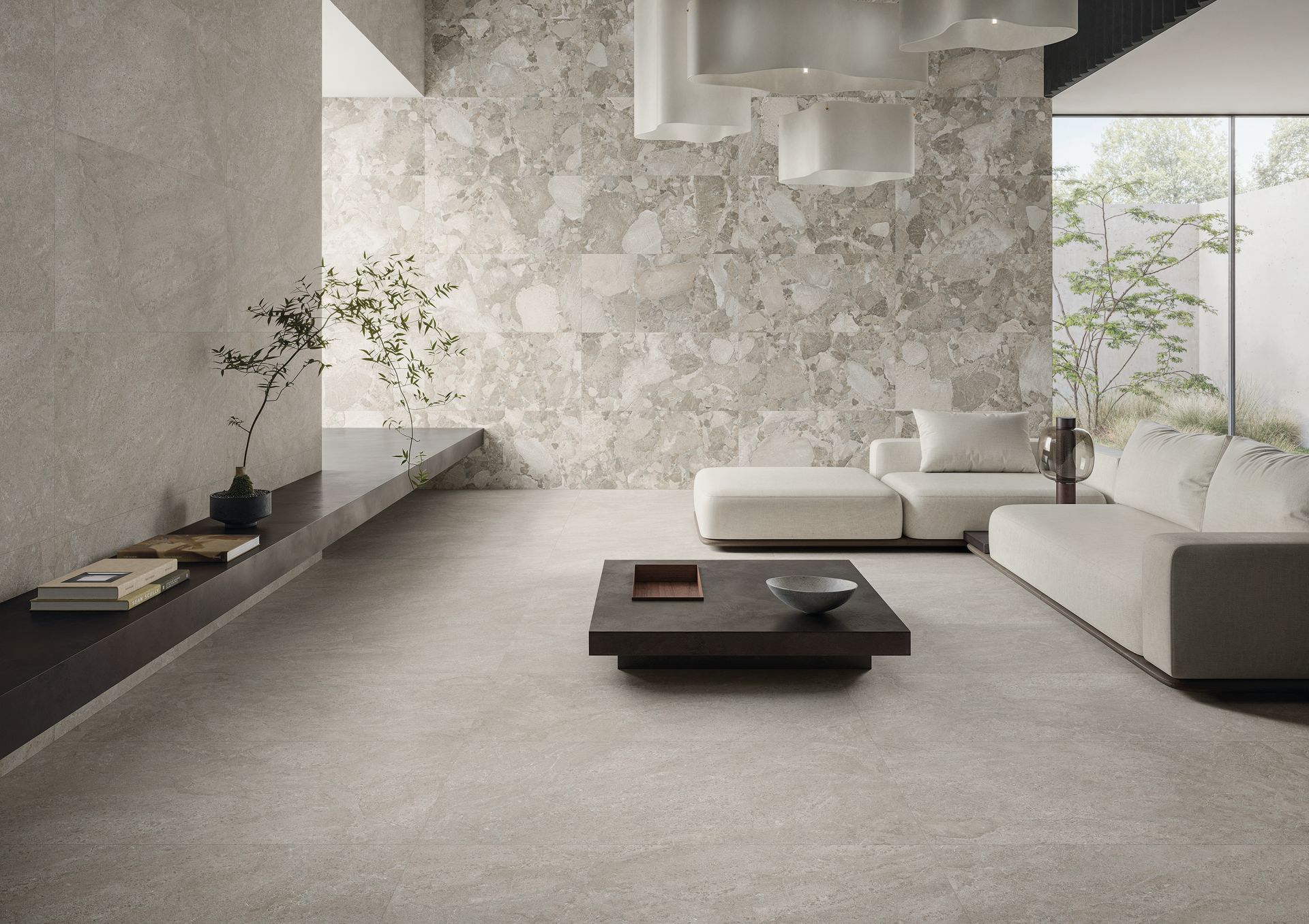 Salon minimaliste moderne avec canapé blanc, table basse noire, mur en pierre texturée et grandes fenêtres