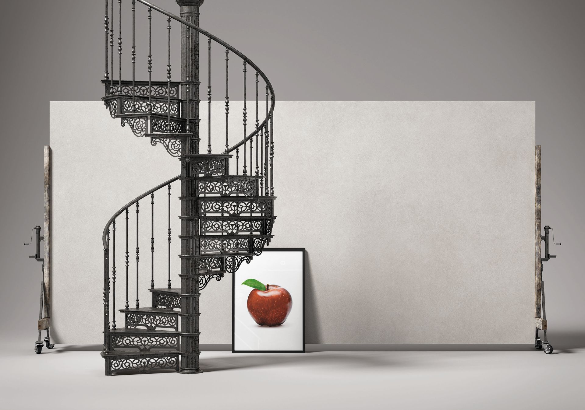 Escalier en colimaçon métallique dans une pièce minimaliste, avec une estampe de fraises encadrée appuyée contre le mur.