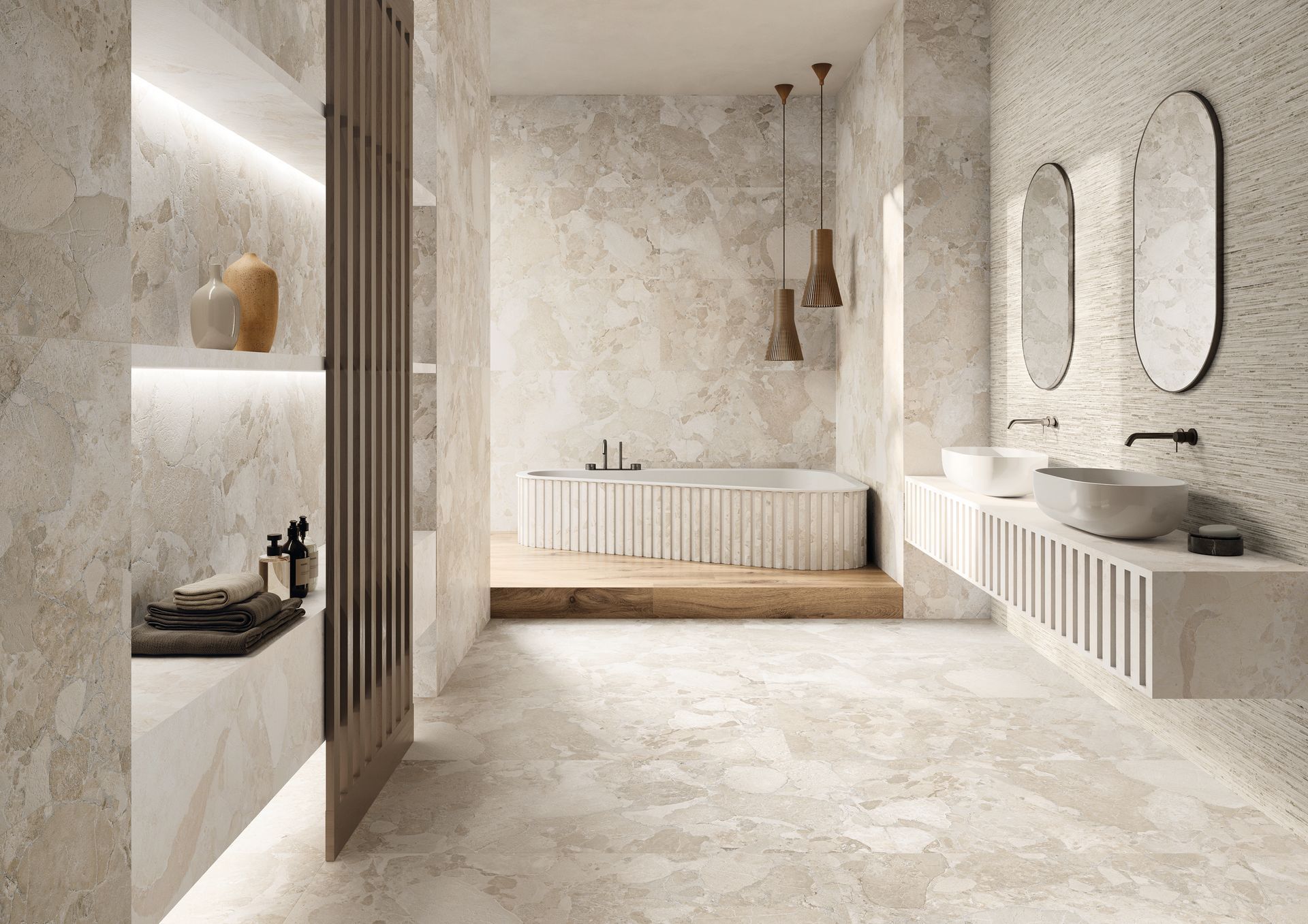 Salle de bains lumineuse et minimaliste avec murs en pierre, meubles-lavabos suspendus, miroirs et baignoire îlot.