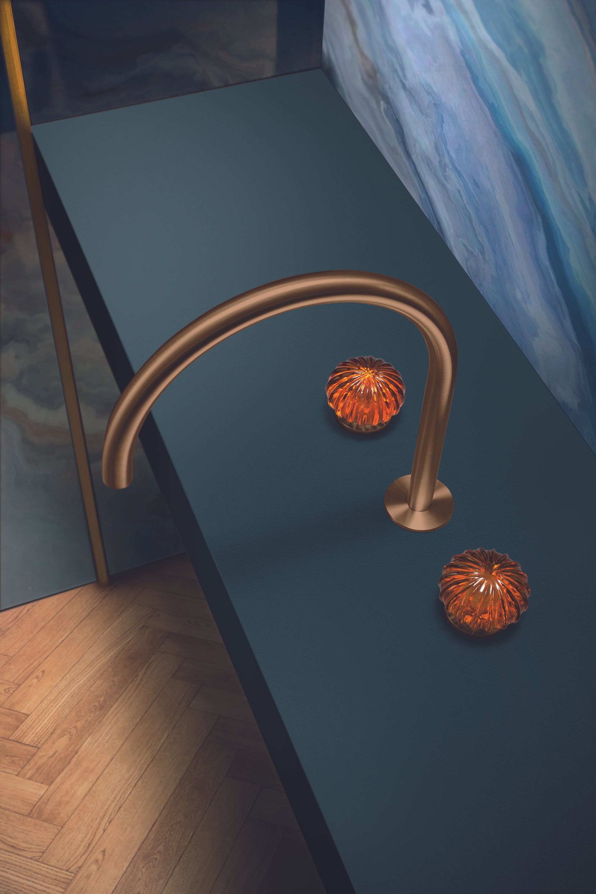Deux sphères texturées orange sur une étagère bleu foncé, à côté d'une sculpture en tige de cuivre courbée.