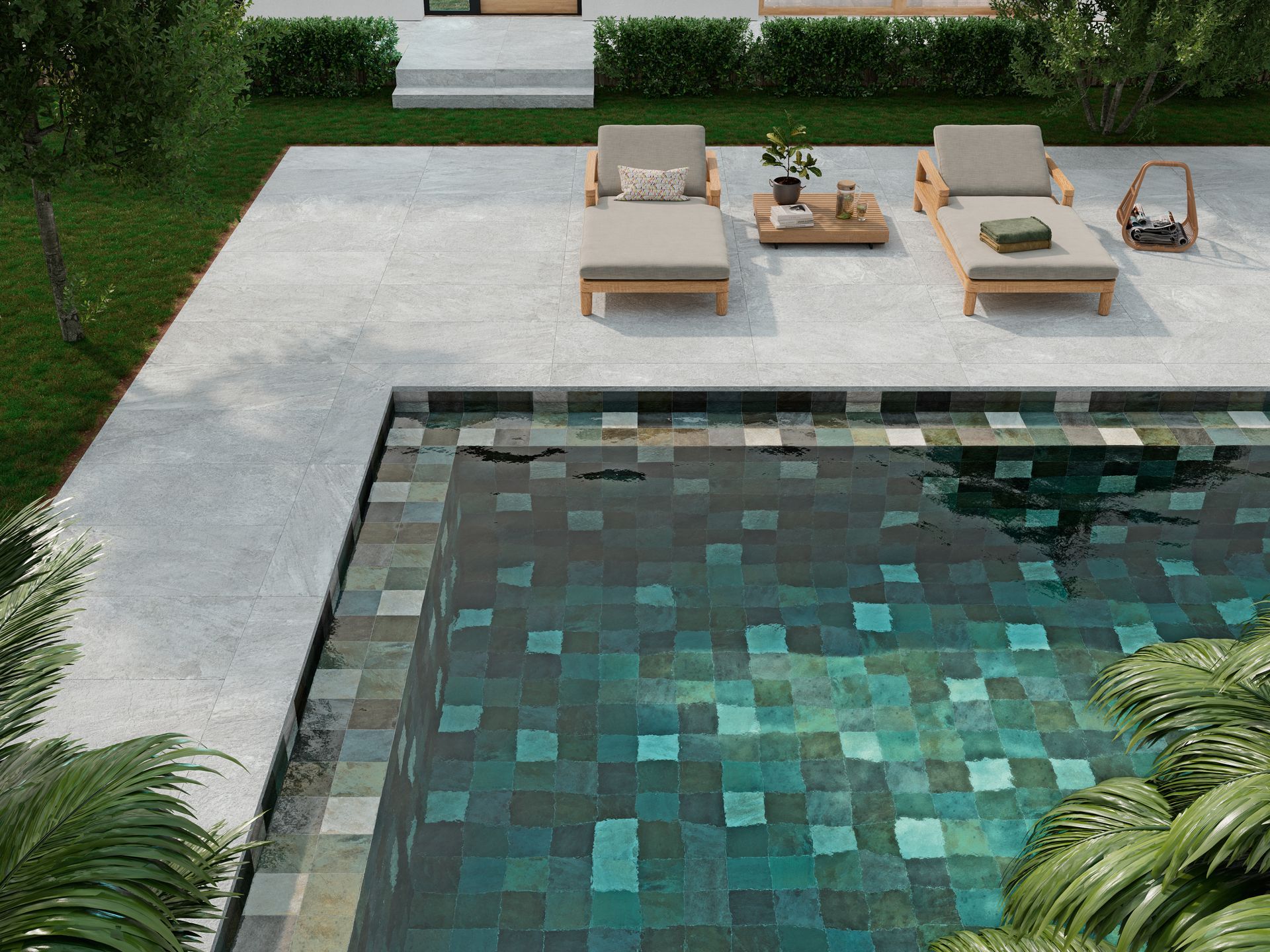 Terrasse moderne au bord de la piscine avec chaises longues, table basse et végétation luxuriante autour d'une piscine carrelée.