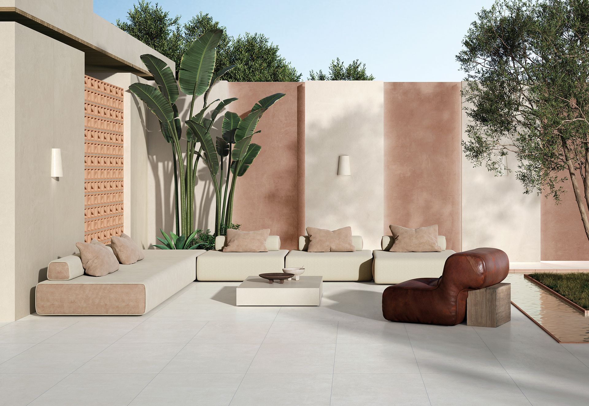 Terrasse extérieure moderne avec murs couleur crème, sièges beiges, plantes en pot et deux chaises longues marron.