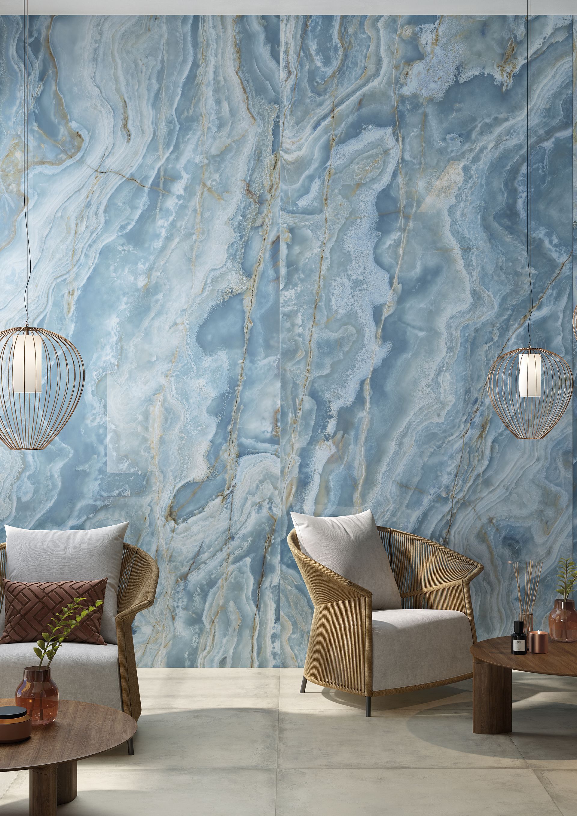 Salon luxueux avec mur en marbre bleu, suspensions lumineuses et fauteuils en osier aux coussins blancs.