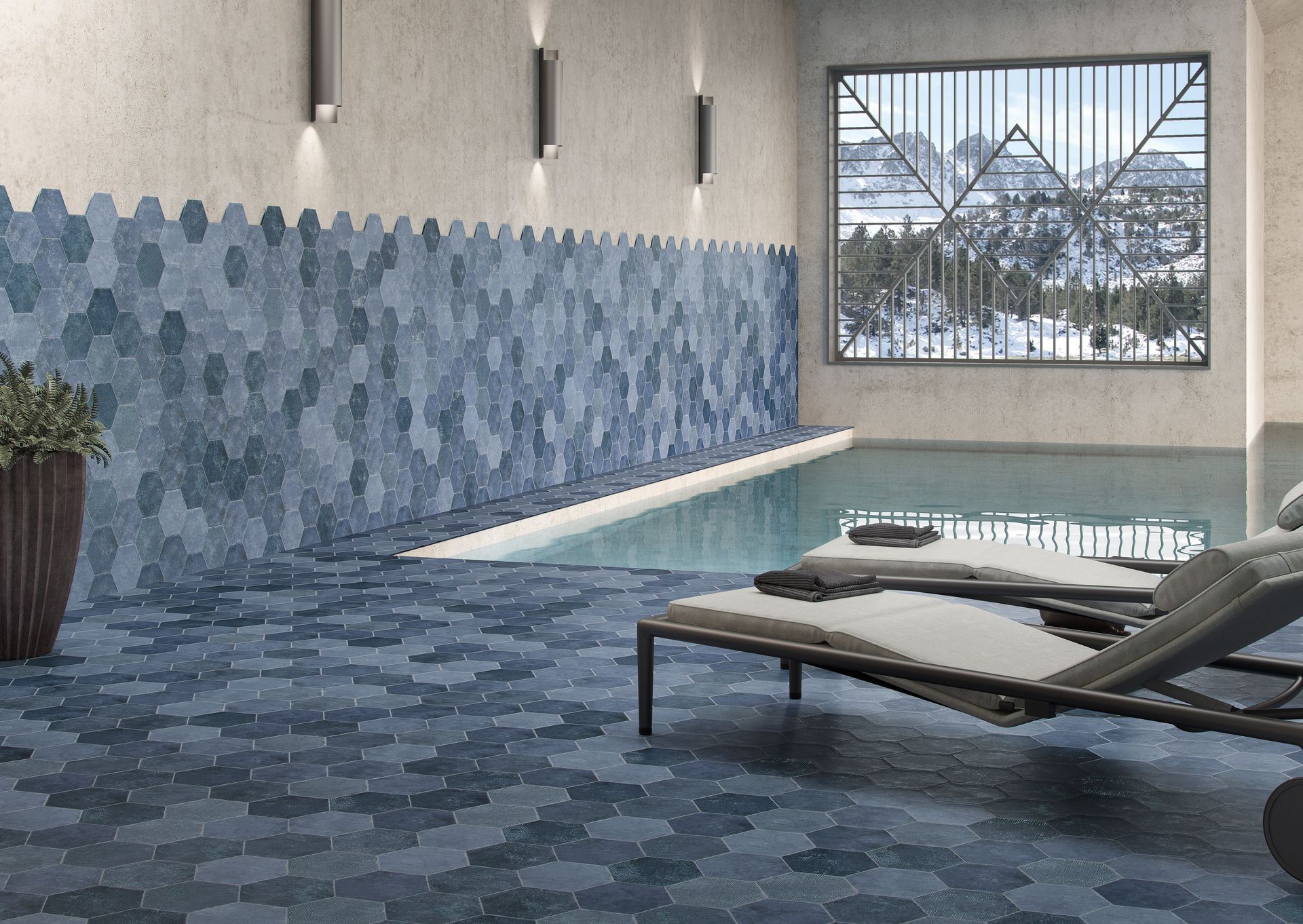 Piscine spa intérieure avec murs en mosaïque bleue, chaises longues et vue sur les montagnes enneigées à travers une fenêtre