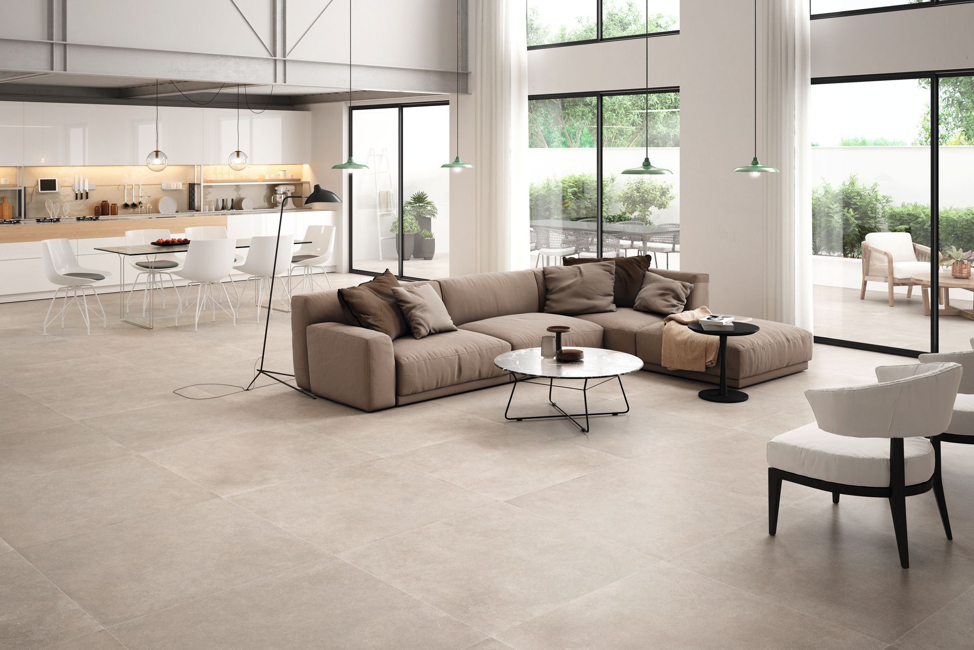 Salon moderne et spacieux avec un canapé d'angle beige, une table basse ronde et une cuisine ouverte en arrière-plan.