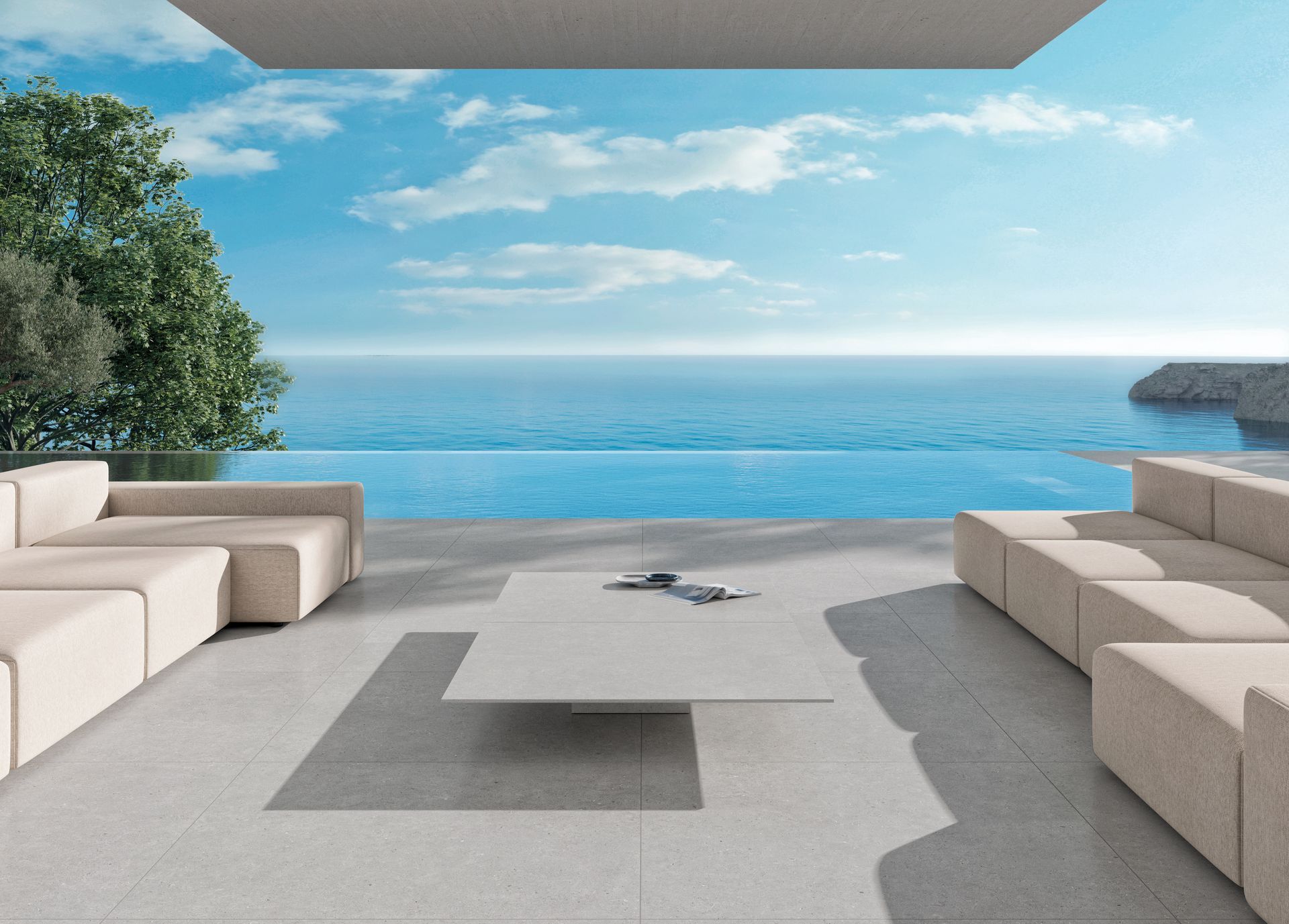 Terrasse moderne avec canapés beiges, table basse et vue sur l'océan au-delà de la piscine à débordement