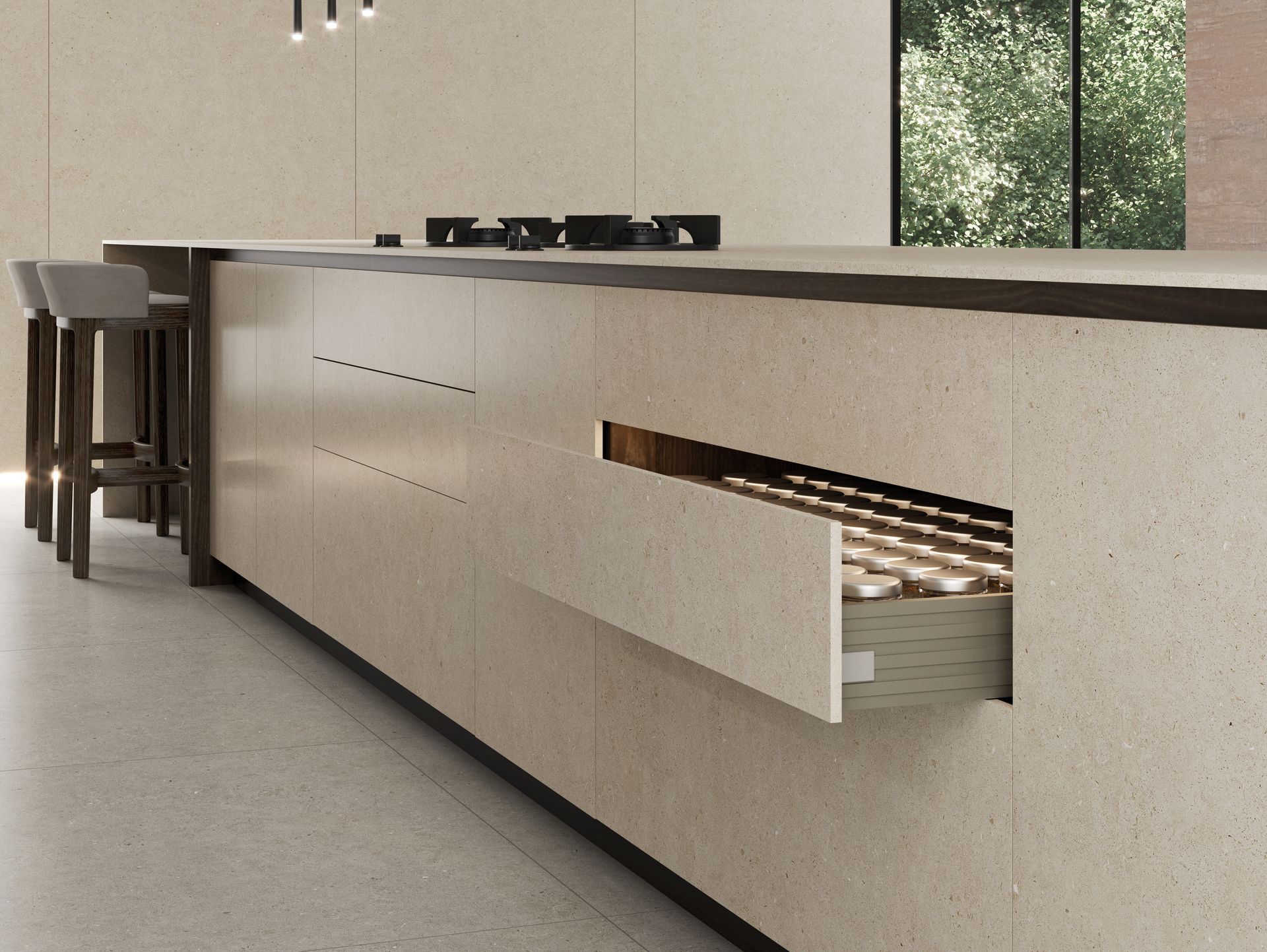 Îlot de cuisine moderne avec placards beiges, plan de travail noir et un tiroir dissimulé qui s'ouvre pour révéler les ustensiles.