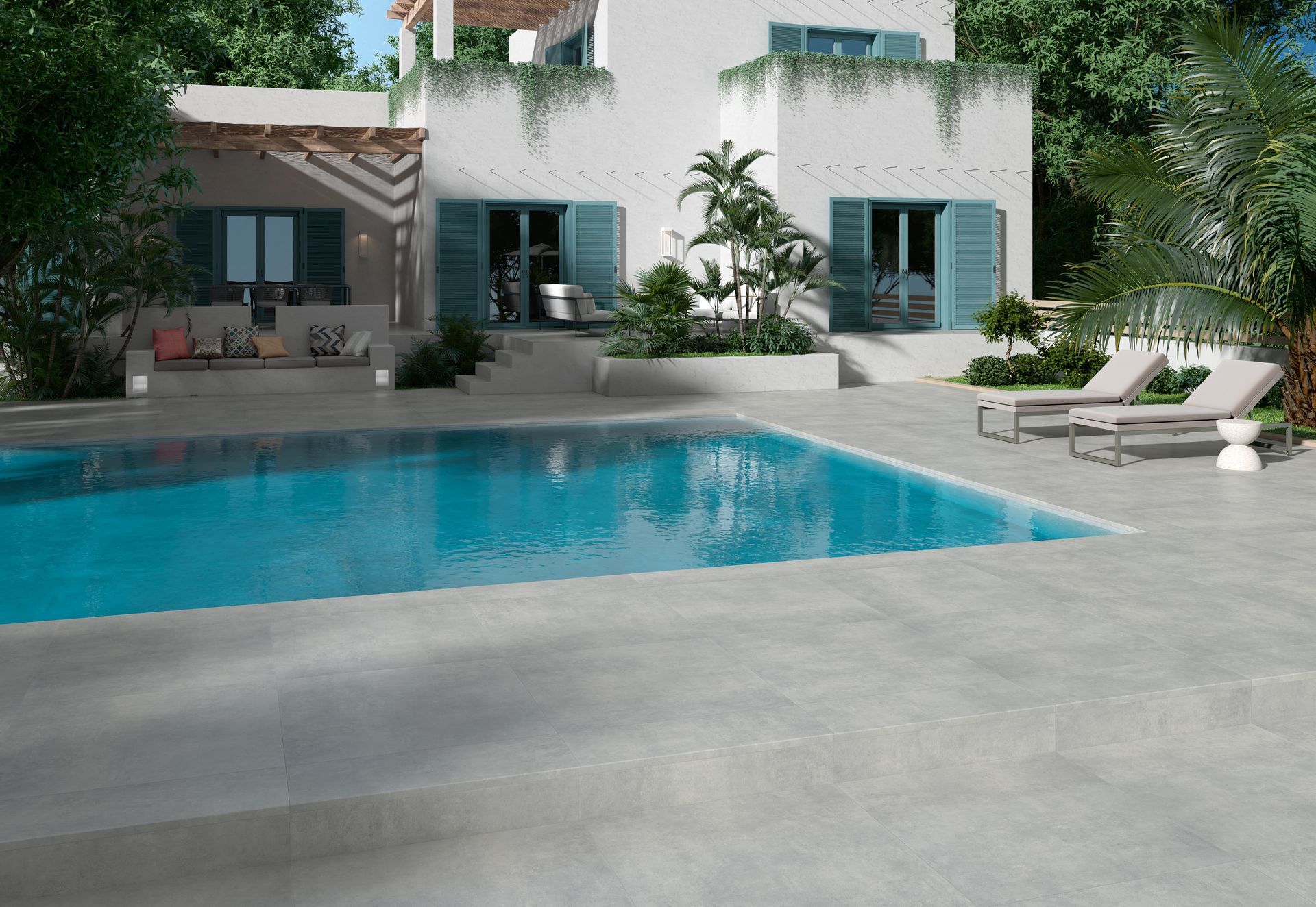 Maison moderne avec piscine turquoise, terrasse grise et chaises longues dans un jardin ensoleillé
