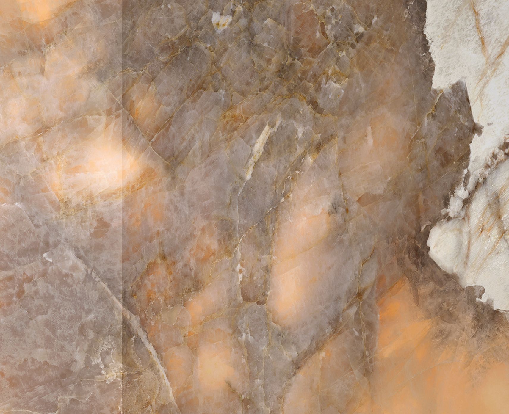 Gros plan sur une surface de pierre brune et grise aux veines ambrées chaudes et aux bords blancs.