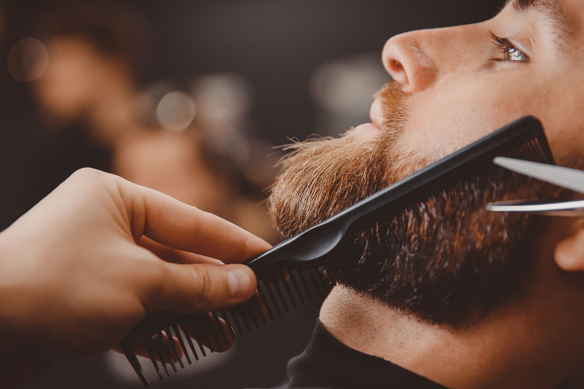 Une personne qui prend soin de la barbe d'une autre personne.