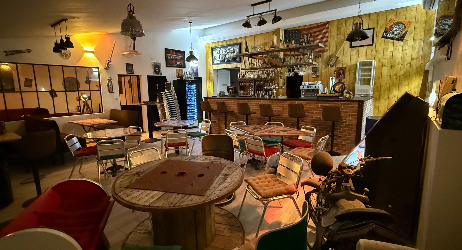 L'intérieur du bar avec des tables en bois.