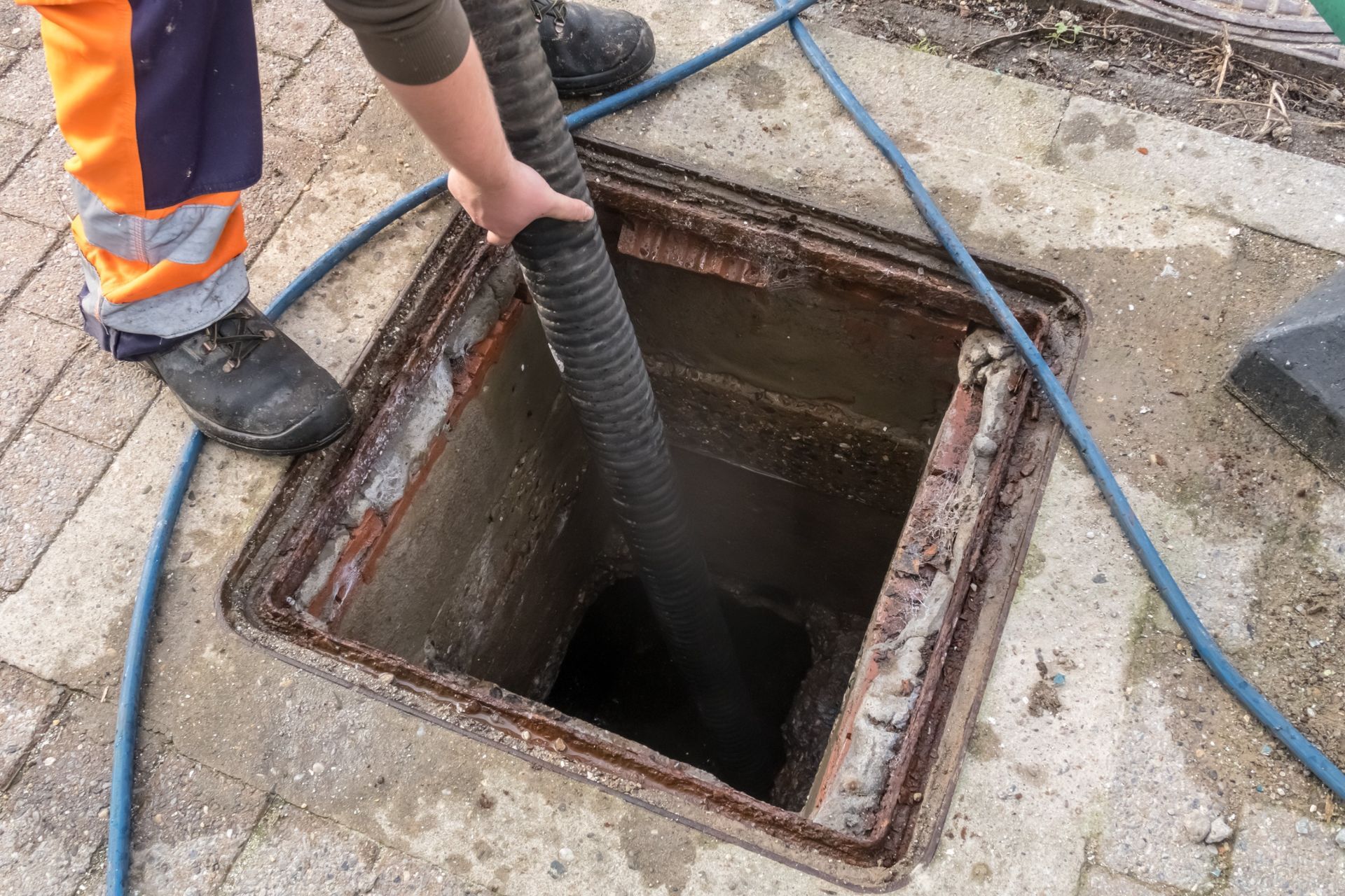 Una persona está bombeando agua hacia la tapa de un pozo.