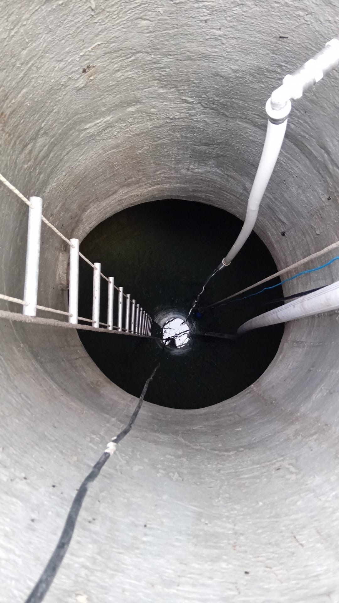Una escalera sube a un pozo lleno de agua.