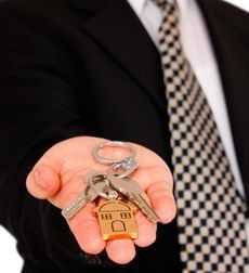 Un hombre con traje y corbata sostiene un manojo de llaves en su mano.