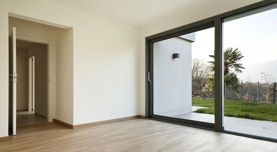 Una habitación vacía con una puerta corrediza de vidrio que conduce a un patio.