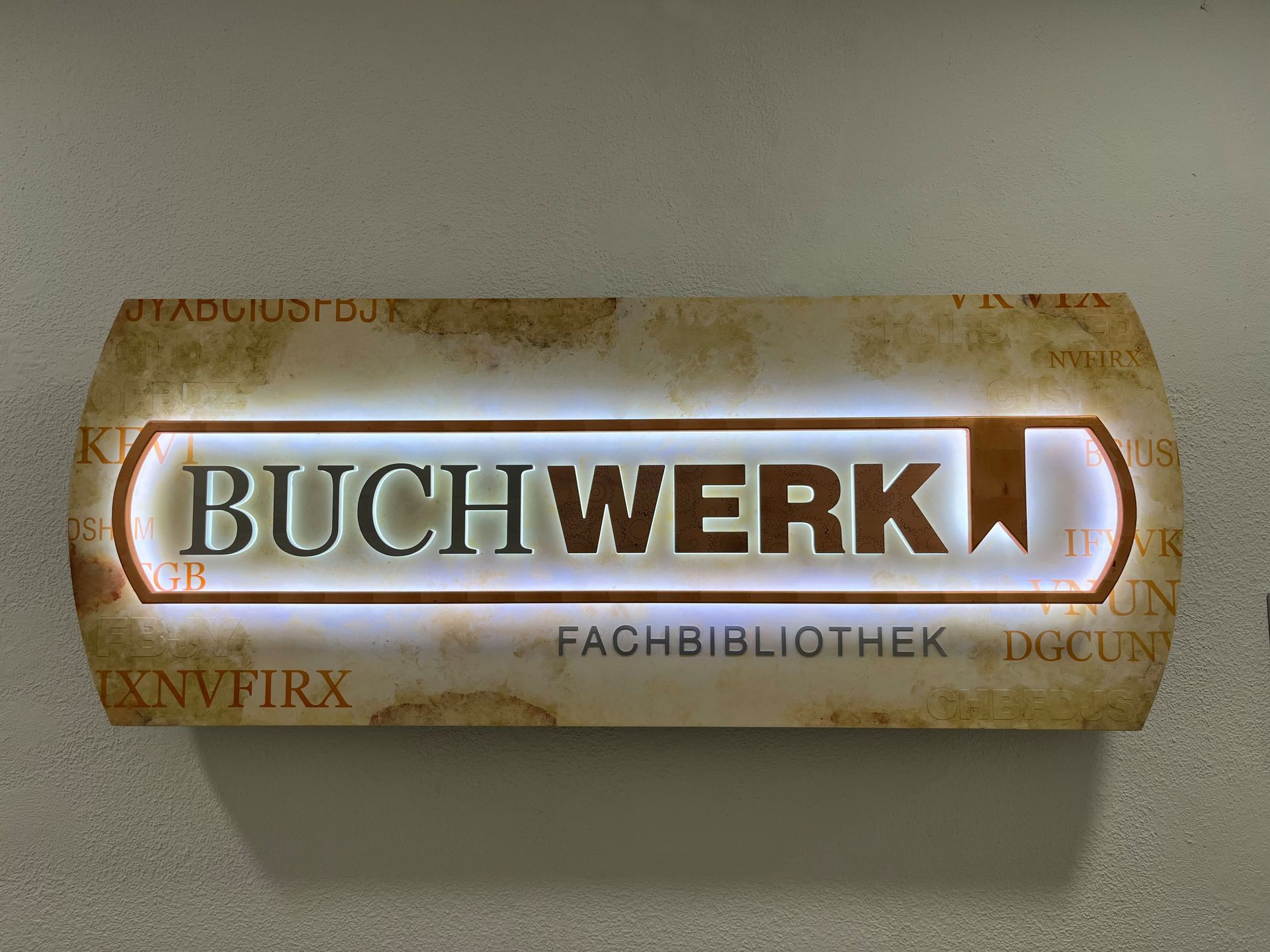 Ein abgenutztes Buchwerk-Hardcover mit gold-weißem Buchrücken auf schlichtem Hintergrund