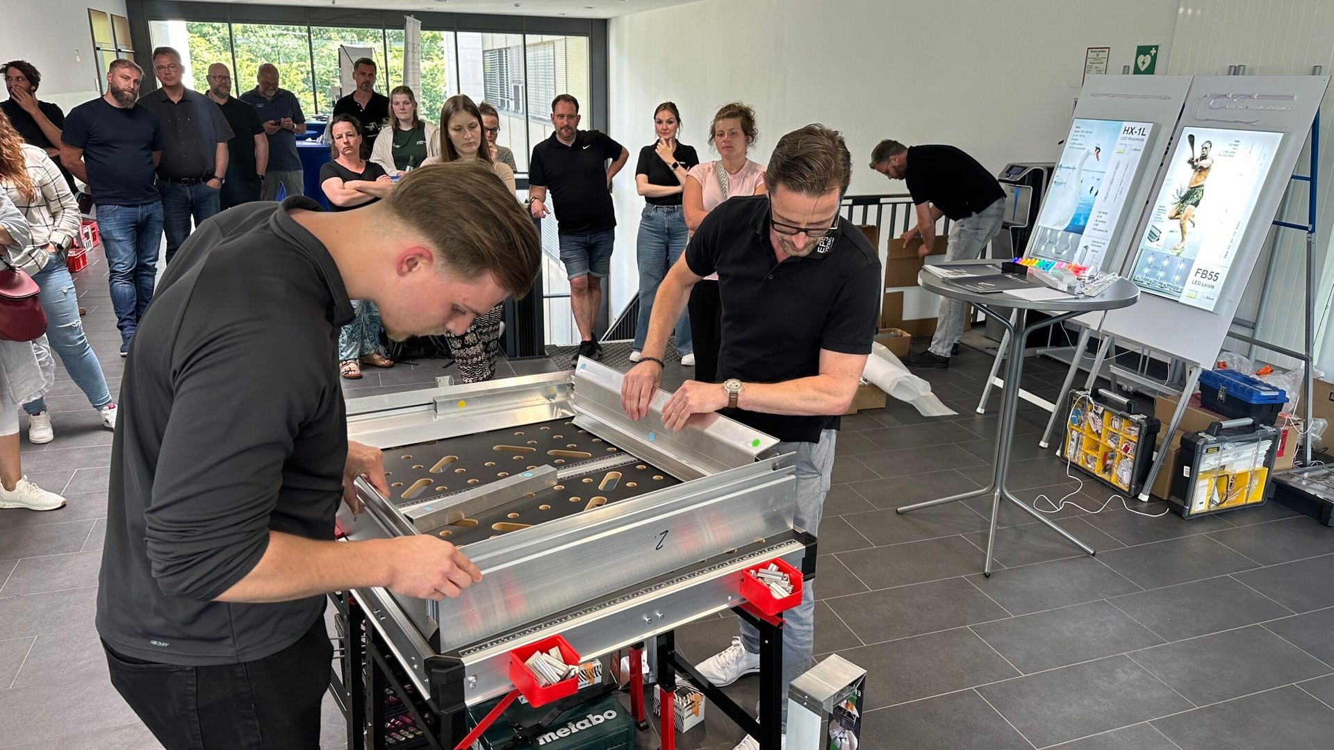 Eine Gruppe von Leuten arbeitet in einem Raum an einer Maschine.