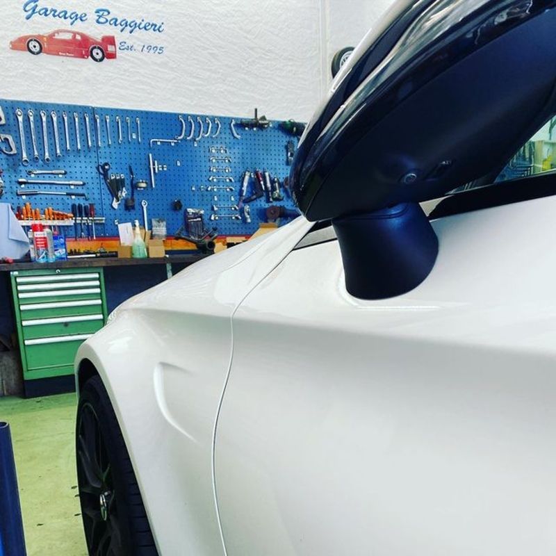 Garage Baggieri – Werkstatt und weisses Auto von der Seite