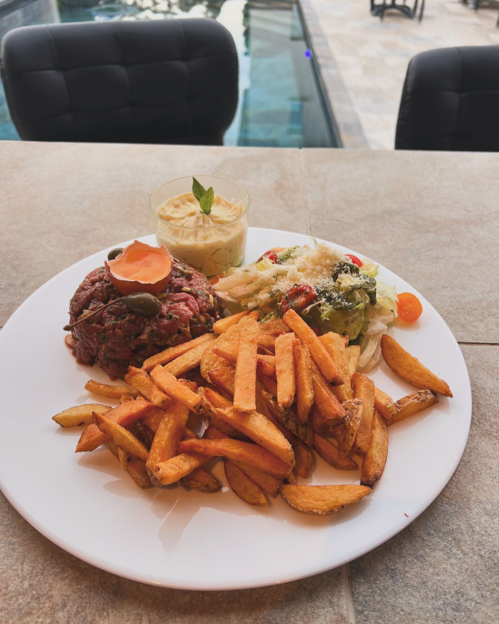 Assiette de frites avec steak, légumes et riz sur une table de restaurant.