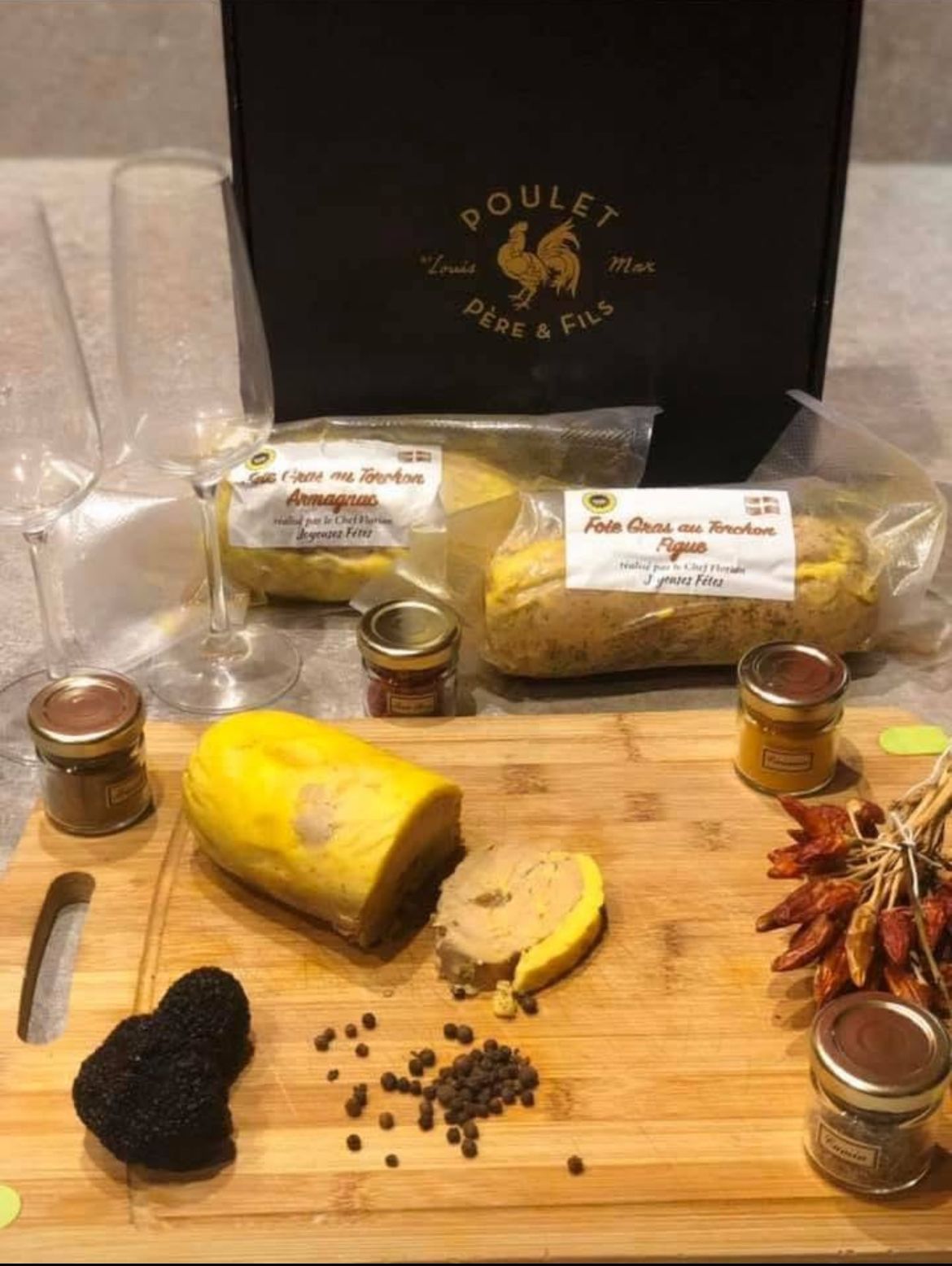 Présentation de produits gastronomiques sur une planche à découper : fromage jaune tranché, morceaux de truffe, grains de poivre, bocaux et produits emballés.