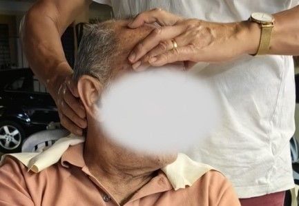 Un uomo anziano riceve un massaggio da una donna.