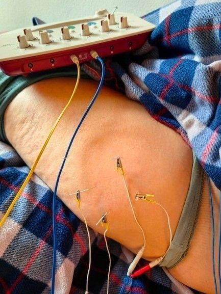 Una persona è sdraiata su un letto con un dispositivo sulla gamba