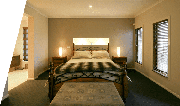 Un dormitorio con una cama grande y dos ventanas.