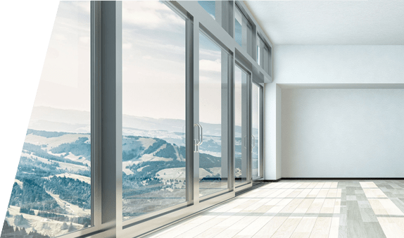 Una habitación vacía con muchas ventanas y vistas a las montañas.