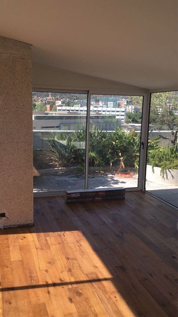 Una sala de estar con piso de madera y una puerta corrediza de vidrio.