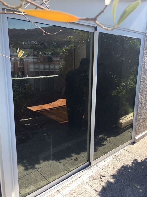 Una puerta corrediza de vidrio con el reflejo de una mesa en ella.