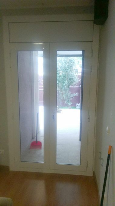 Una habitación con una puerta corrediza de vidrio que conduce a un balcón.