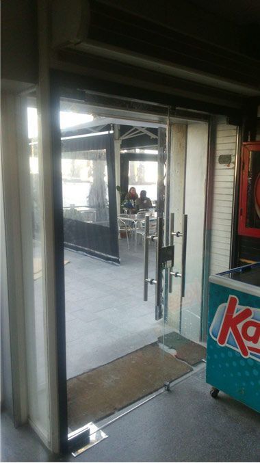 Un enfriador de helado Kahlua está al lado de una puerta de vidrio.