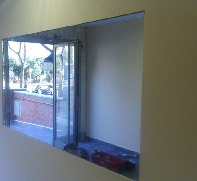 Una ventana en una pared con vista a una calle.