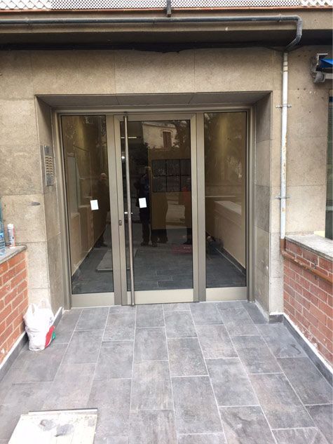 Un edificio con una puerta de vidrio y una pared de ladrillo