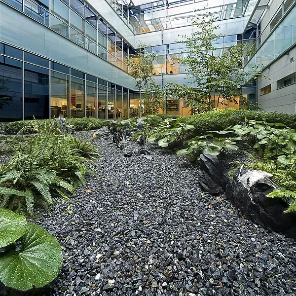 Un gran edificio con un jardín en el medio.