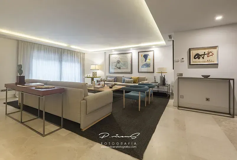 Una sala de estar con un sofá, sillas y una mesa.