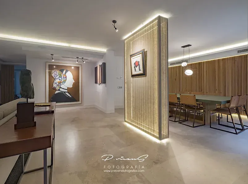 Una sala de estar con comedor y un cuadro en la pared.