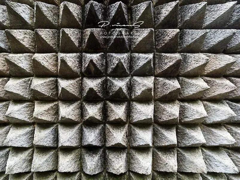 Un primer plano de un muro de piedra con forma de pirámide.