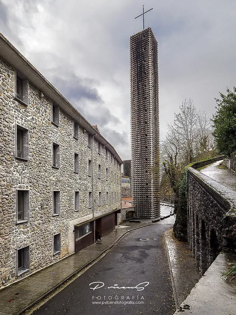 Un edificio de piedra con una cruz encima.
