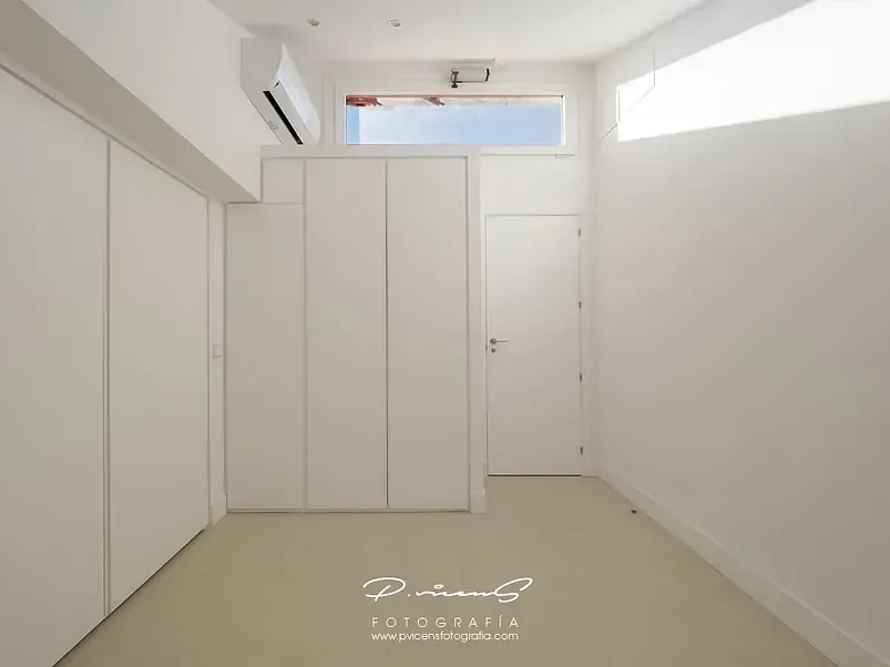 Una habitación vacía con paredes blancas y una ventana.
