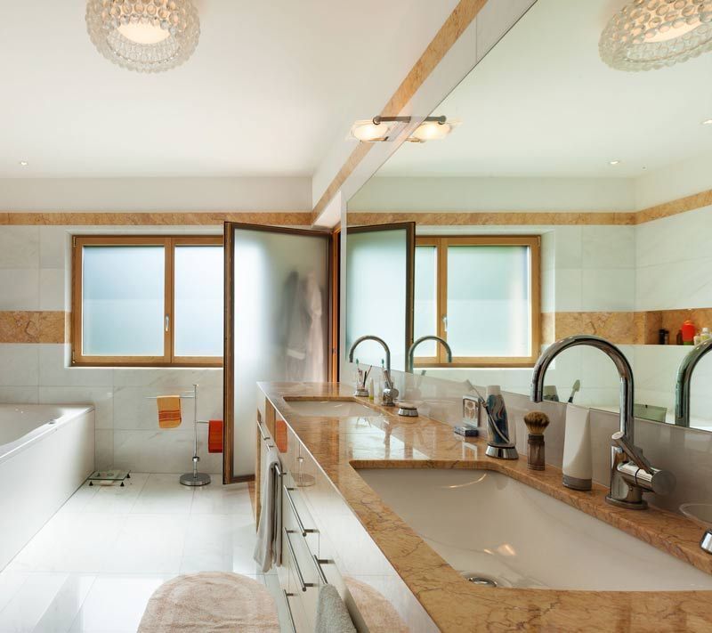 Un baño con dos lavabos y un espejo grande.