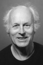 Una fotografía en blanco y negro de un hombre calvo sonriendo.