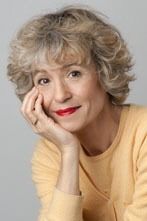 La mujer lleva un suéter amarillo y lápiz labial rojo.