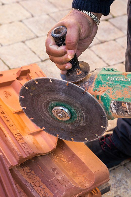 Ouvrier qui découpe une tuile