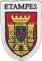 Écusson portant l'inscription « ÉTAMPES » au-dessus d'armoiries. Ces dernières représentent un château et un écu orné.