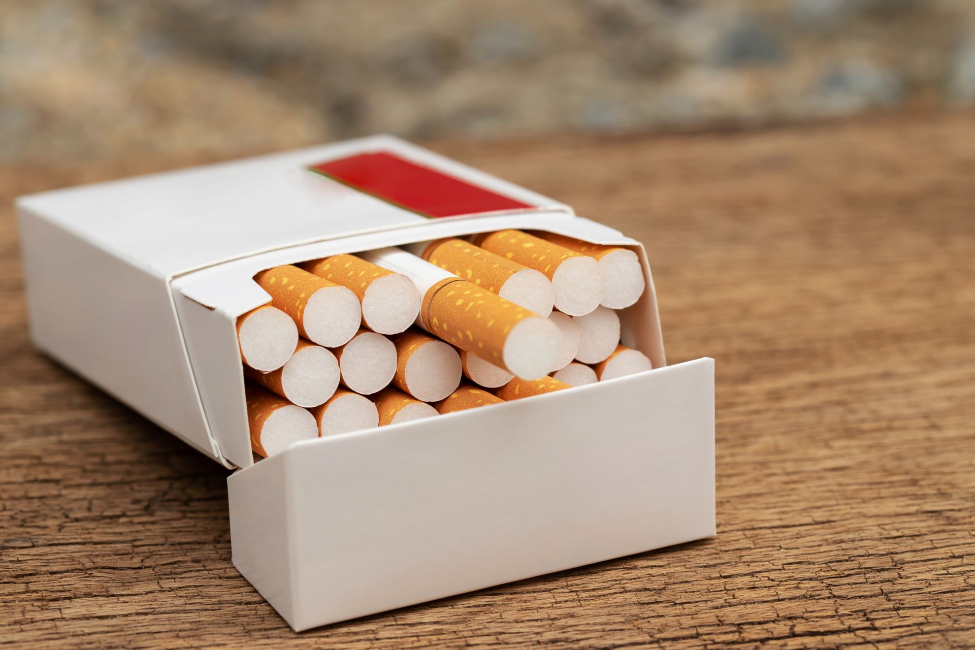 Una caja de cigarrillos está sobre una mesa de madera.